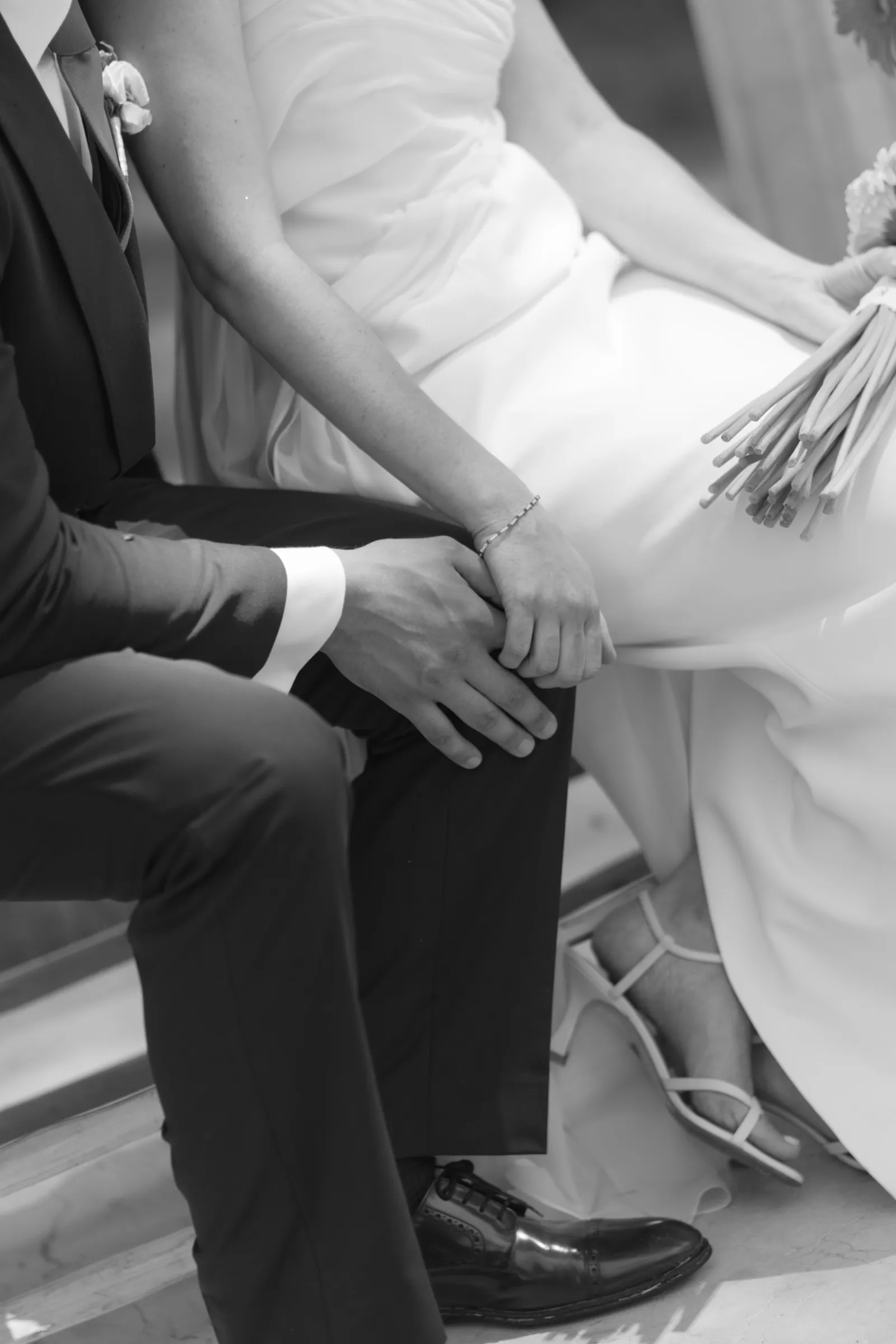 Novios sentados de la mano, en blanco y negro